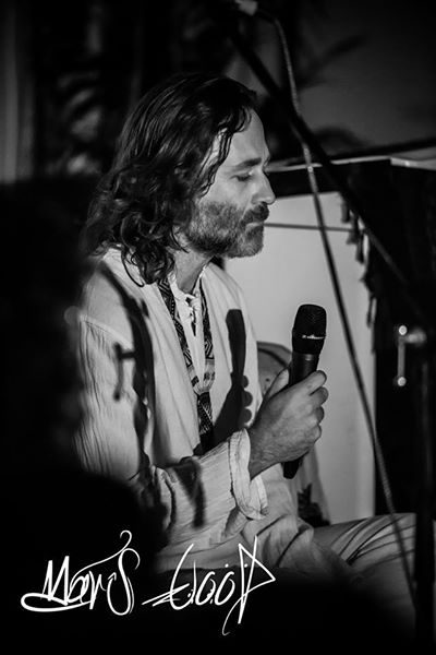Lore Solaris seated with a microphone, speaking, in black and white